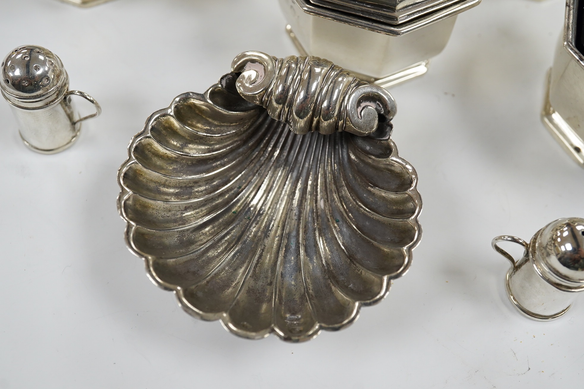 A George V five piece silver condiment set, Birmingham, 1931, two miniature 925 pepperettes and a silver shell salt. Condition - fair